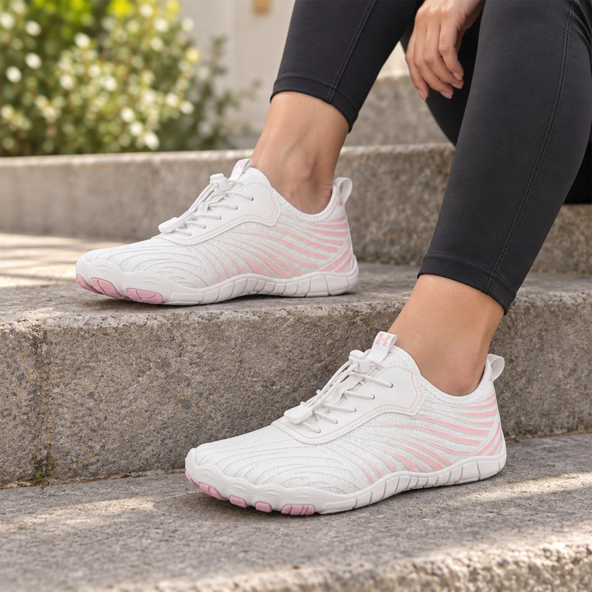 Zapatillas barefoot Icona Evo blancas y rosas en unas escaleras